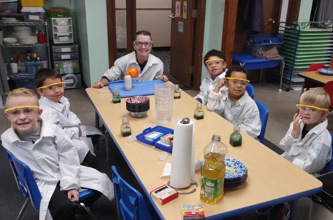Kids in lab coats working on a science project